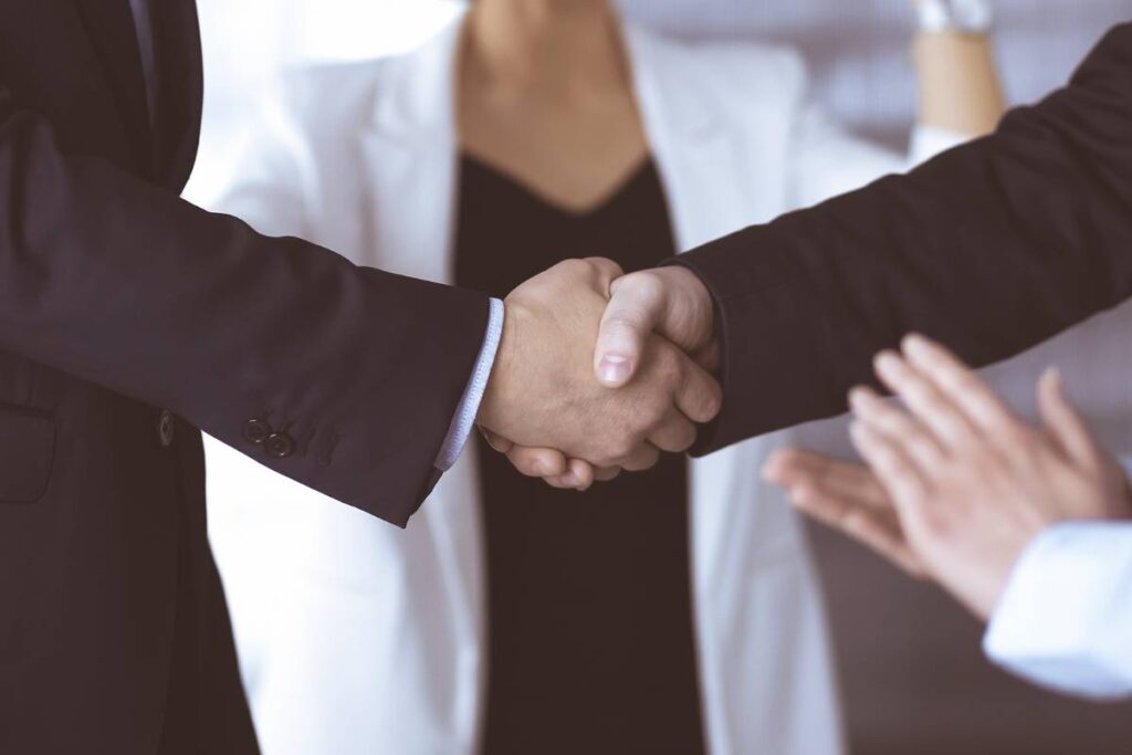 Photo of two men in business suits shaking hands