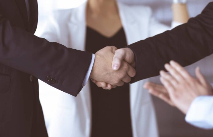 Photo of two men in business suits shaking hands