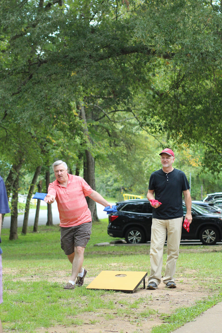 Synergists playing cornhole at company picnic