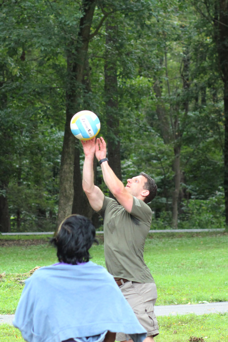 Synergist playing volleyball at company picnic