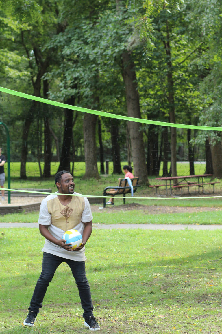 Synergist playing volleyball at company picnic