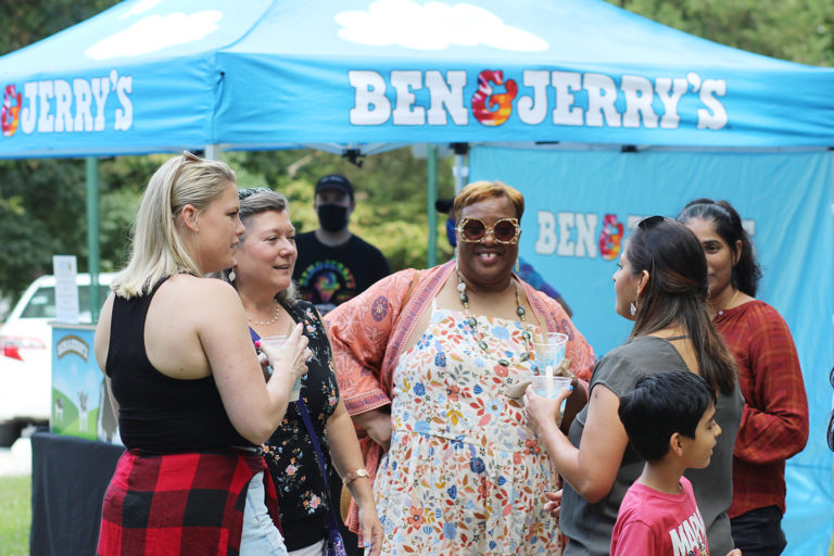 Photo of group of women talking at the company picnic (Ben & Jerry's tent in the background)
