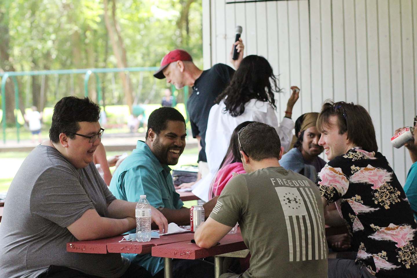 Photo of a team of Synergists laughing together at the company picnic