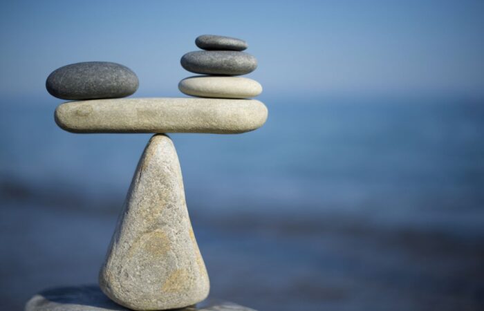 Image of pebbles balanced on top of each other at the water's edge