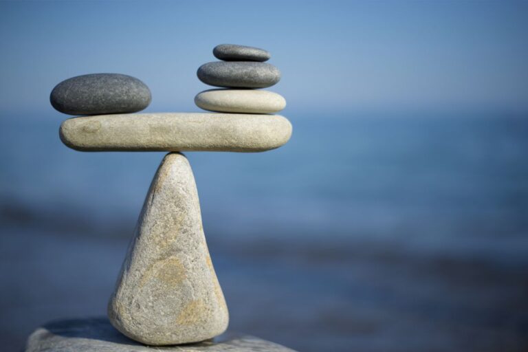 Image of pebbles balanced on top of each other at the water's edge
