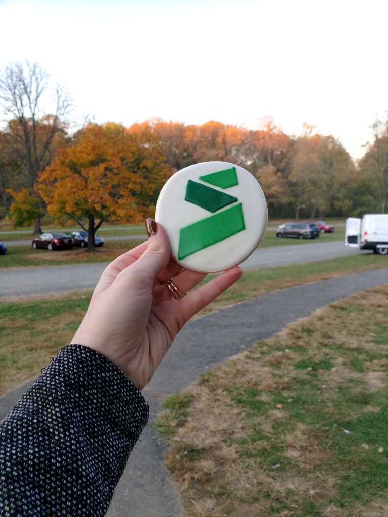 Holding a Synergy-themed cookie