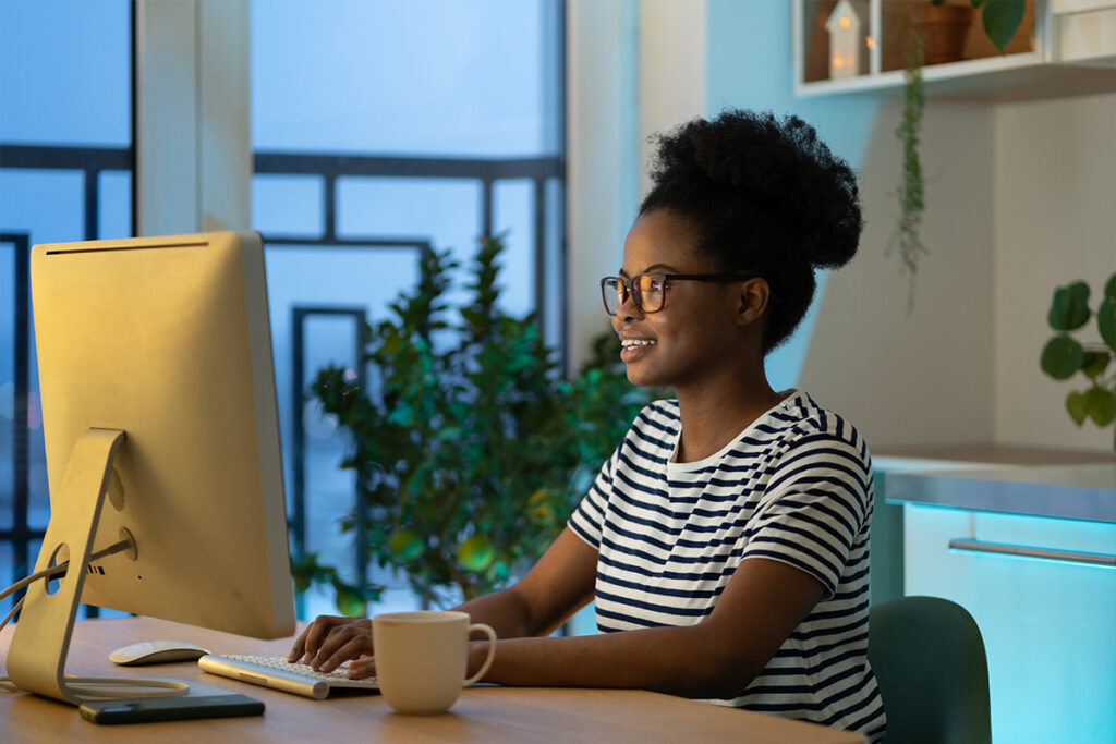 Smiling woman at computer in the evening